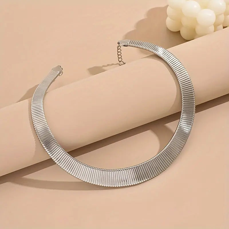 Collier choker torque en or blanc posé.