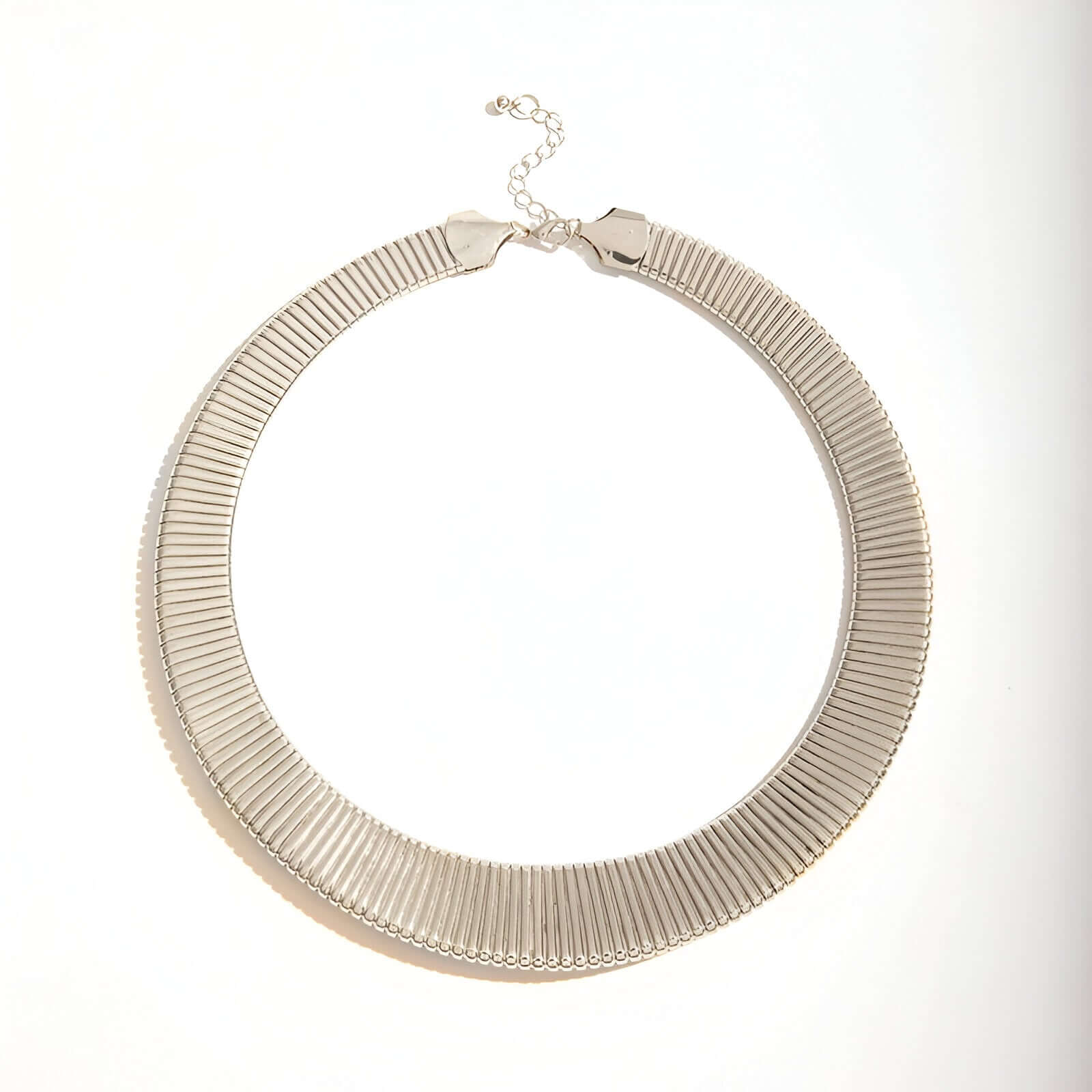 Collier choker torque en or blanc sur fond blanc.