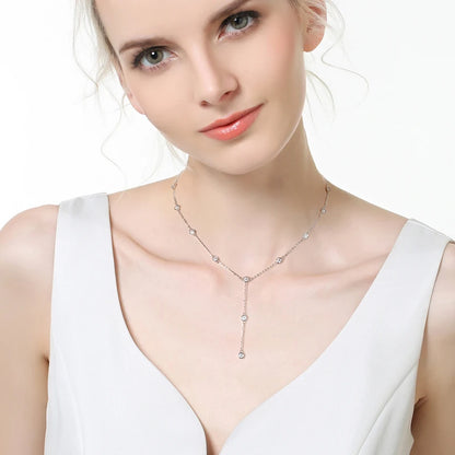 Sautoir court en argent 925 plaqué or blanc et moissanites porté au cou d'une femme.
