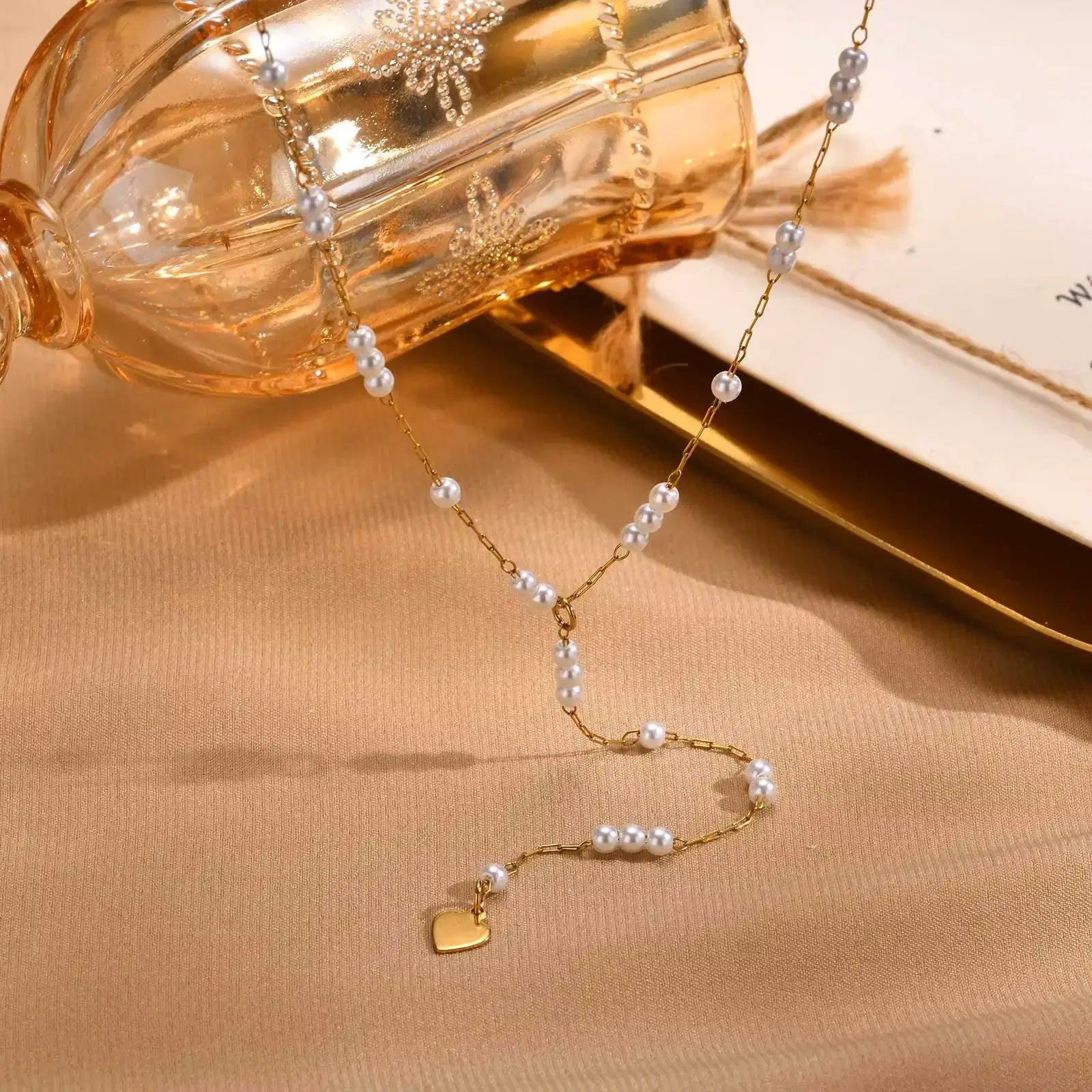 Collier sautoir fantaisie en acier doré orné de perles vue de face.