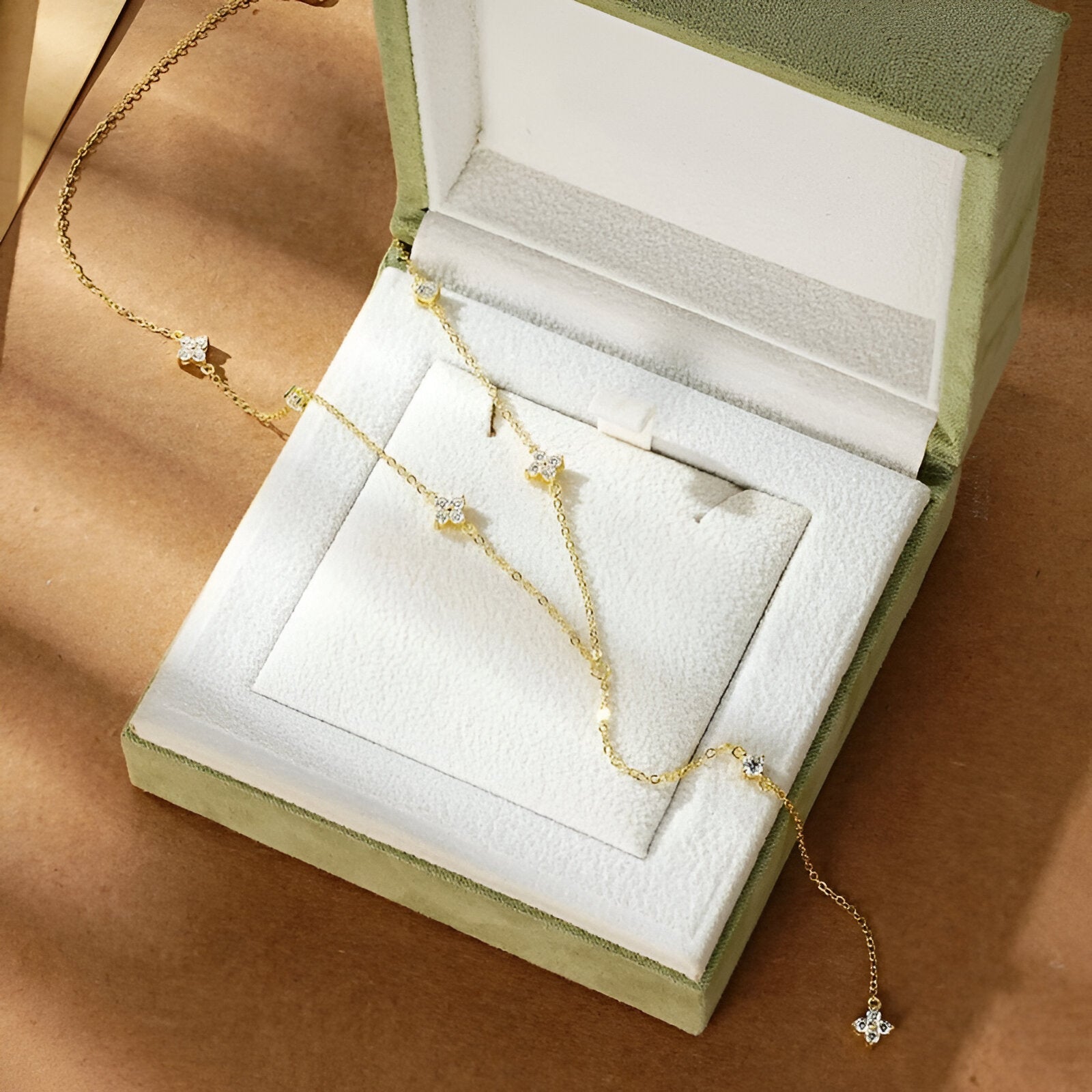 Sautoir fleurs maille dorée lumineuse en argent 925 plaqué or jaune chaleureux et diamants à plat sur son écrin.