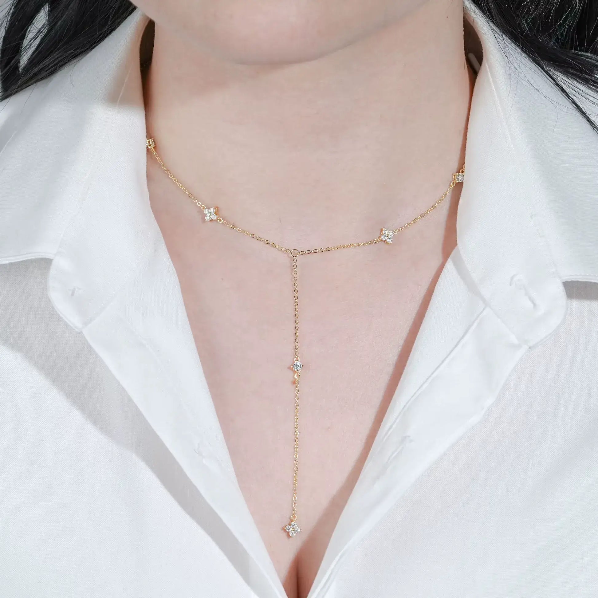 Sautoir fleurs maille dorée lumineuse en argent 925 plaqué or jaune et diamants porté au cou d'une femme vue de face.
