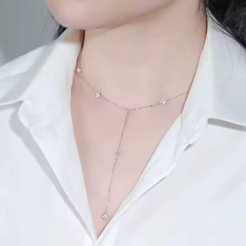 Sautoir floral chaîne argentée discrète en argent 925 plaqué or blanc et moissanites étincelantes porté au cou d'une femme vue de côté.