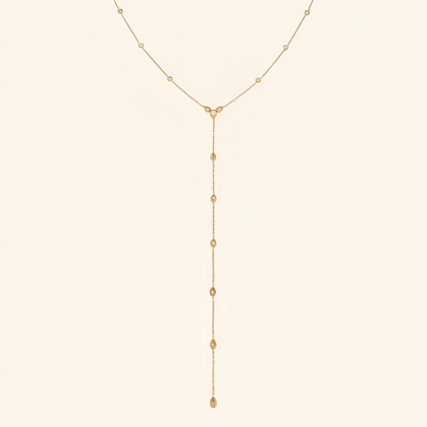 Sautoir goutte d'eau en acier inoxydable plaqué or jaune et diamants naturels sur fond blanc.