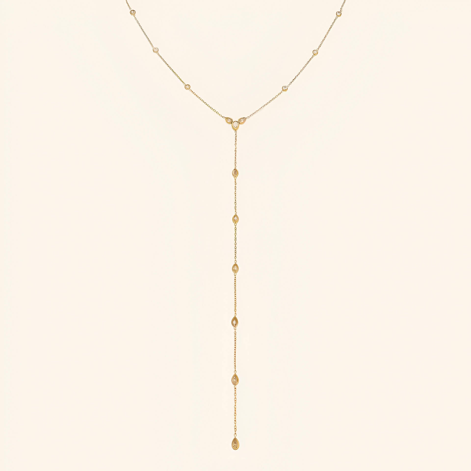 Sautoir goutte d'eau en acier inoxydable plaqué or jaune et diamants naturels sur fond blanc.