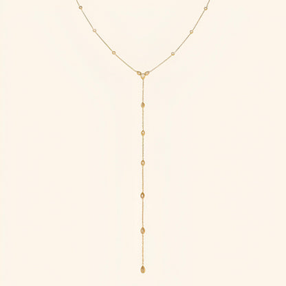 Sautoir goutte d'eau en acier inoxydable plaqué or jaune et diamants naturels sur fond blanc.
