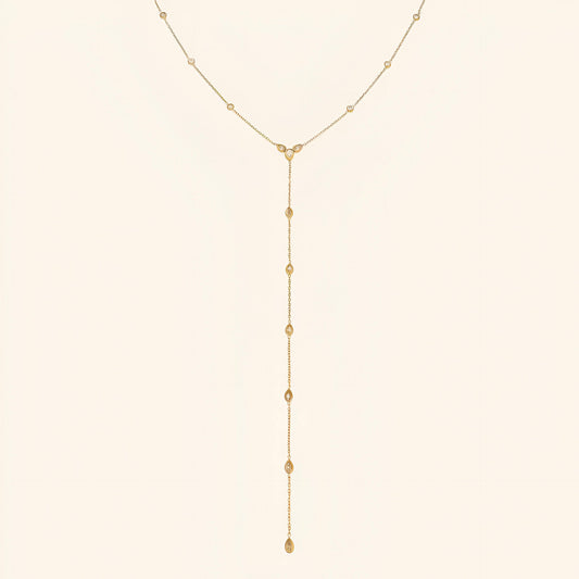 Sautoir goutte d'eau en acier inoxydable plaqué or jaune et diamants naturels sur fond blanc.