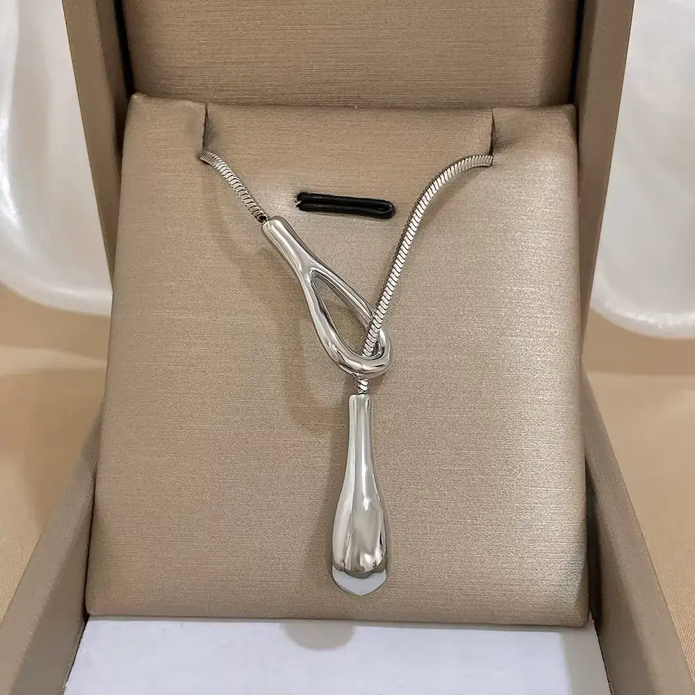Sautoir larme argentée ajustable en acier inoxydable 316L plaqué or blanc rangé dans son écrin.