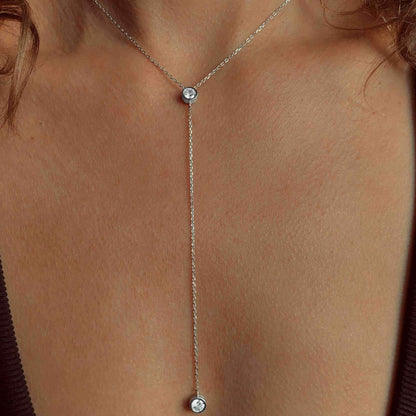 Sautoir long pendentif en argent 925 plaqué or blanc et diamants porté au cou d'une femme vue de face.