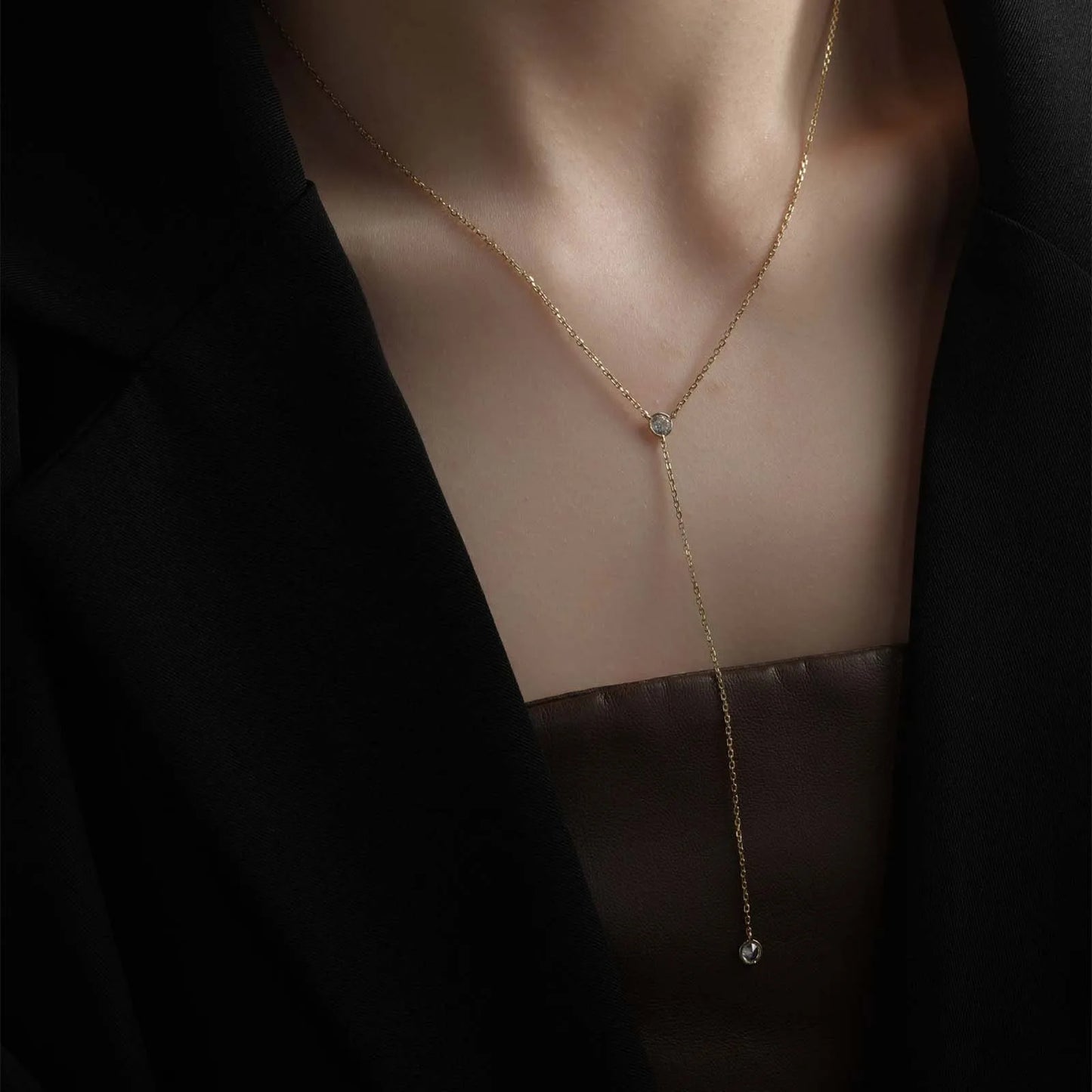 Sautoir long pendentif en argent 925 plaqué or jaune lumineux et diamants en zircon porté au cou d'une femme.