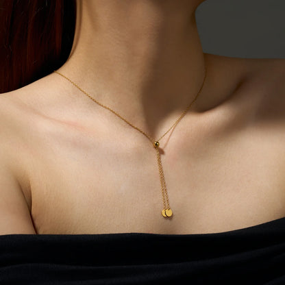 Sautoir maille forçat en argent 925 plaqué or jaune avec perle amovible porté au cou d'une femme vue de loin.