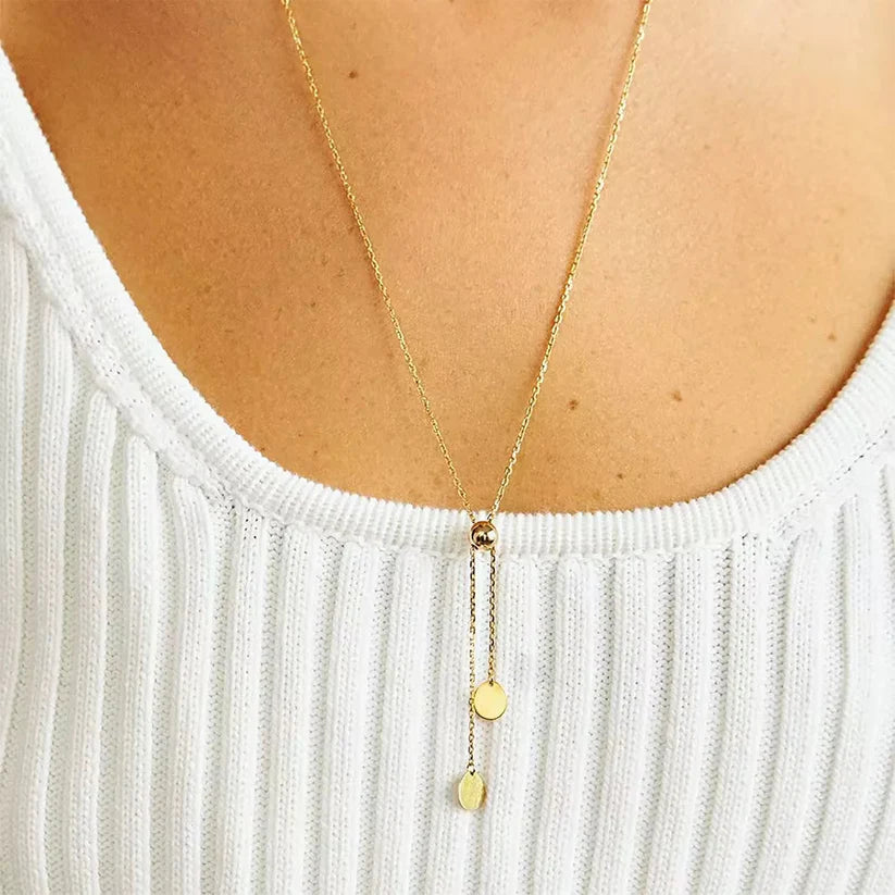 Sautoir ajustable maille forçat en argent 925 plaqué or jaune avec perle amovible porté au cou d'une femme vue de proche.