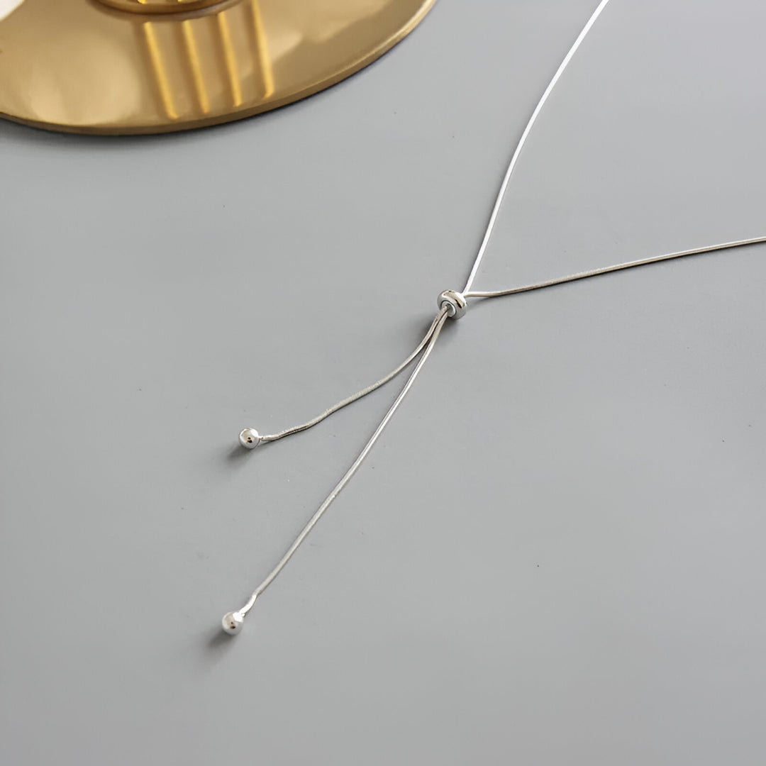 Collier sautoir perle synthétique amovible en acier inoxydable plaqué or blanc vue de côté.