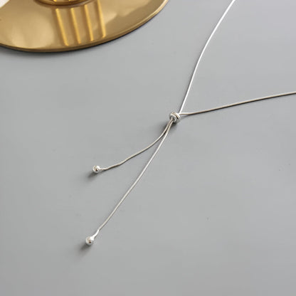 Collier sautoir perle synthétique amovible en acier inoxydable plaqué or blanc vue de côté.