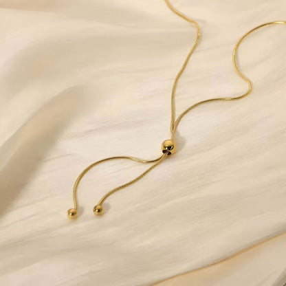 Sautoir perle synthetique amovible en acier doré orné de perle amovible à plat.