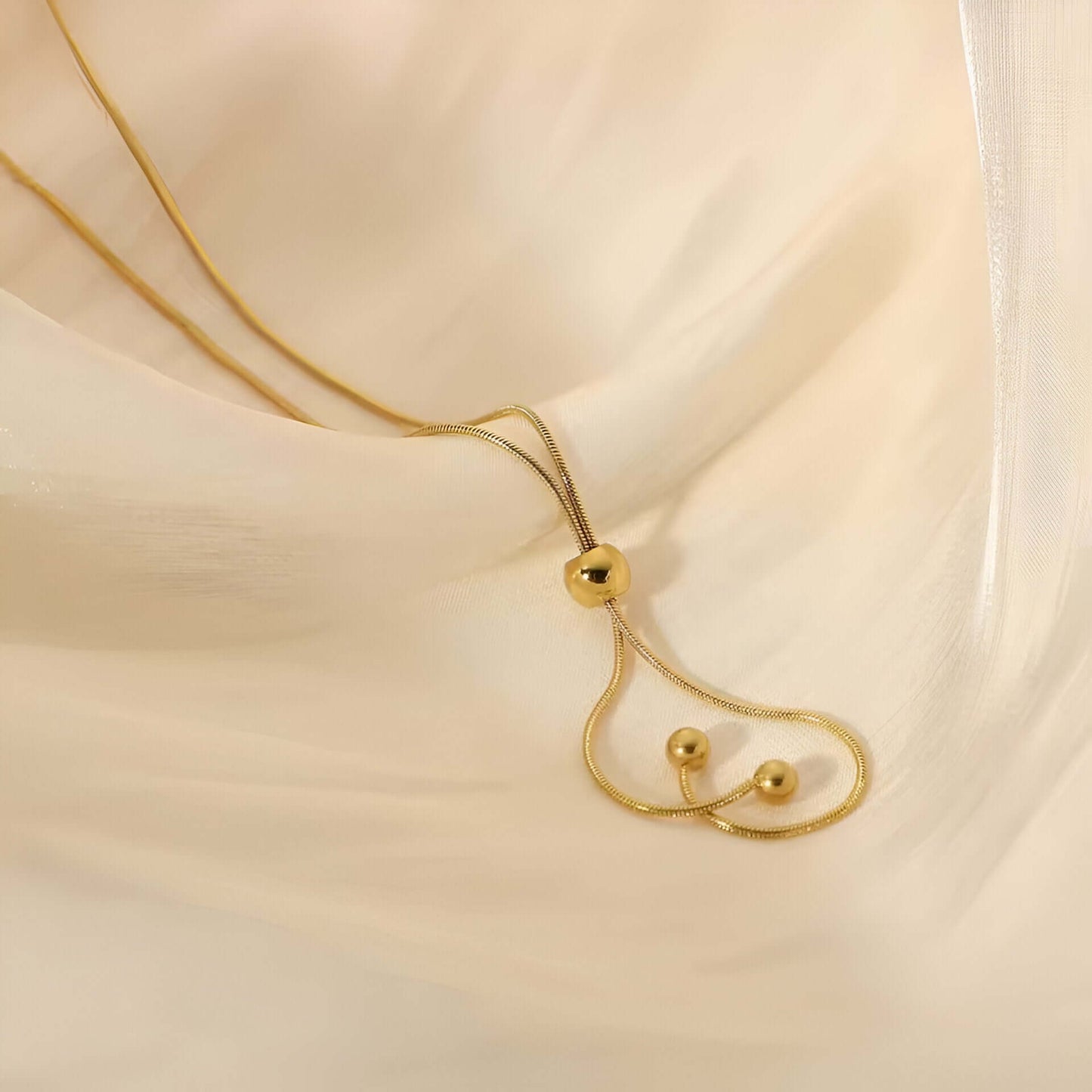 Sautoir perle synthetique amovible en acier doré orné de perle amovible posé.