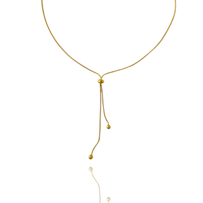 Sautoir perle synthetique amovible en acier doré orné de perle amovible sur fond blanc.